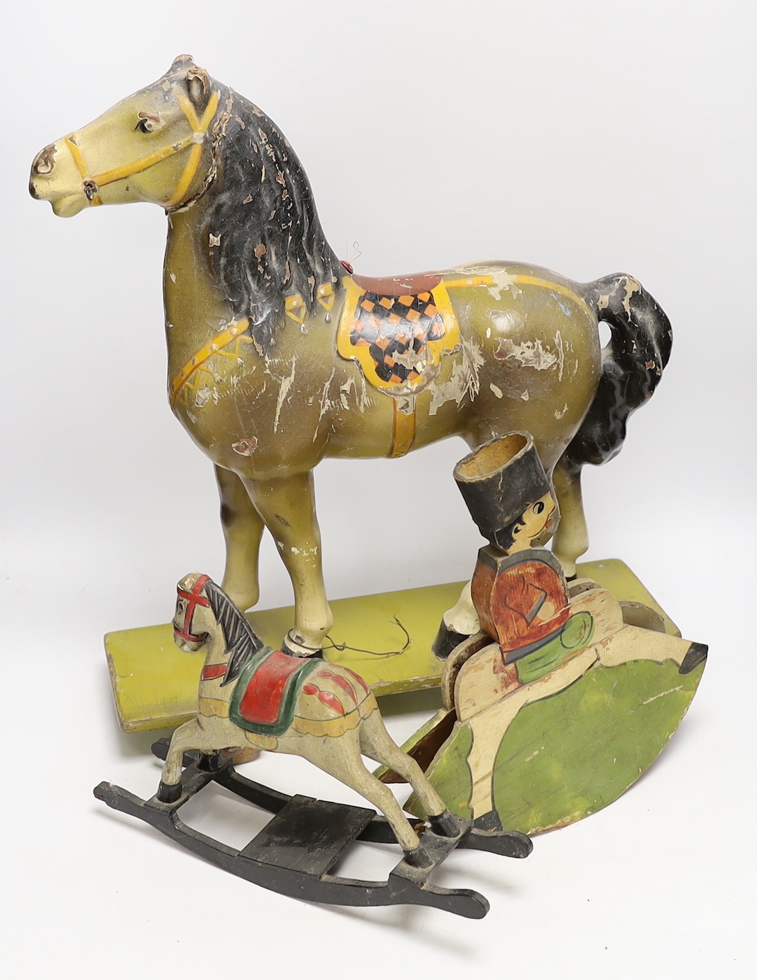A toy pull-along horse and two toy rocking horse models